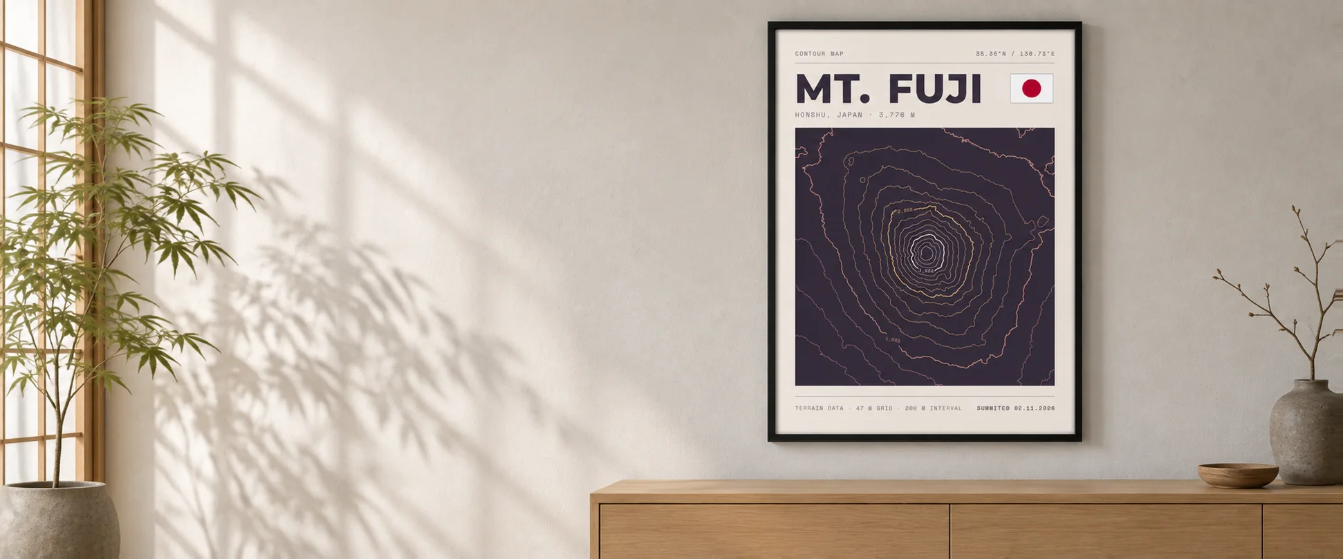 A framed Mt. Fuji topographic poster in a black frame above a pale oak sideboard
